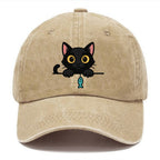 Midnight the black cat holding a tiny yarn ball between both paws while peeking Washed Cap