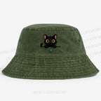 Midnight the black cat holding a tiny yarn ball between both paws while peeking Washed Bucket Hat
