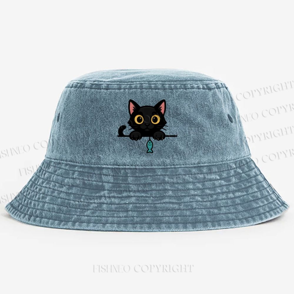 Midnight the black cat holding a tiny yarn ball between both paws while peeking Washed Bucket Hat