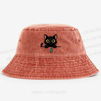 Midnight the black cat holding a tiny yarn ball between both paws while peeking Washed Bucket Hat
