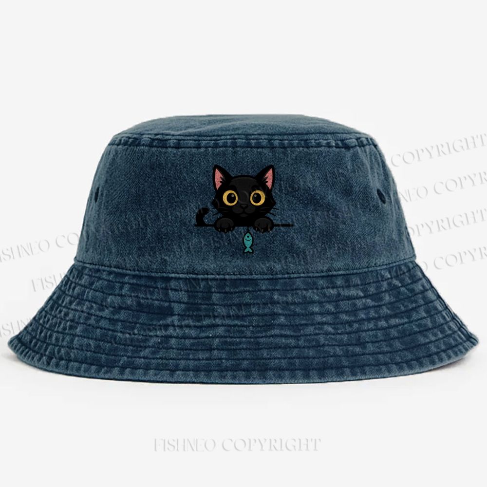 Midnight the black cat holding a tiny yarn ball between both paws while peeking Washed Bucket Hat
