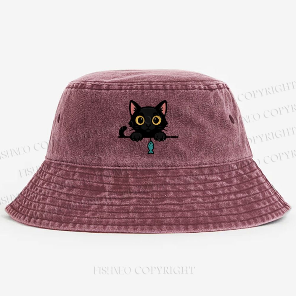 Midnight the black cat holding a tiny yarn ball between both paws while peeking Washed Bucket Hat